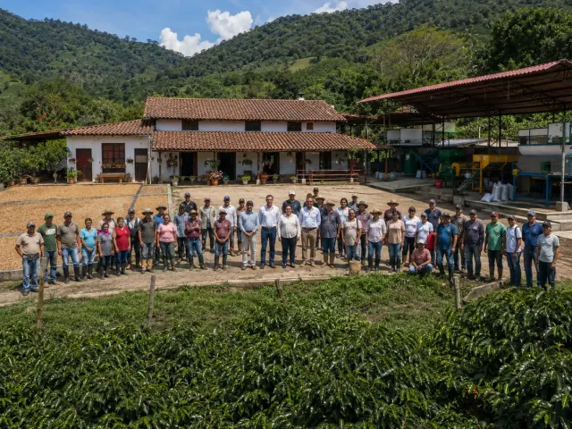 Grupo de trabajadores reunido en el patio de una finca